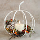 White Metal Cage Pumpkin candle holder adding warmth and rustic charm to home decor.