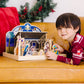 A kid playing with the Melissa & Doug Classic Wooden Christmas Nativity Set With 4-Piece Stable and 11 Wooden Figures