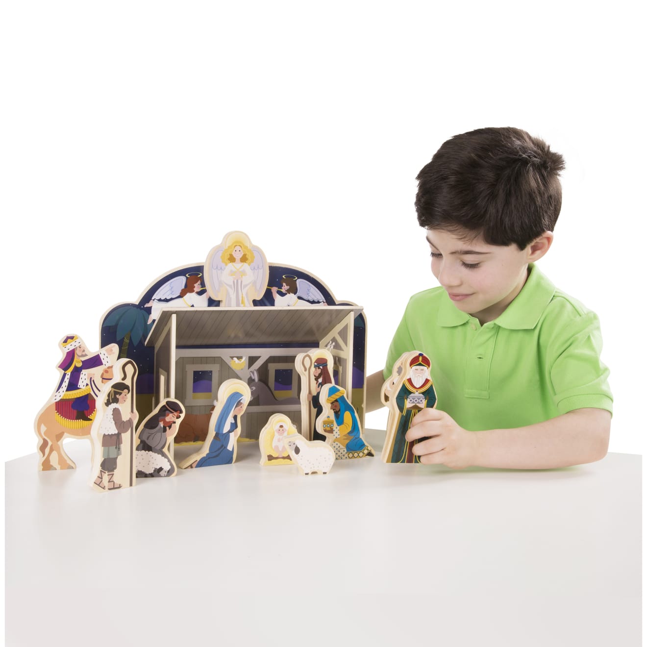 A child on white background with the Melissa & Doug Classic Wooden Christmas Nativity Set With 4-Piece Stable and 11 Wooden Figures