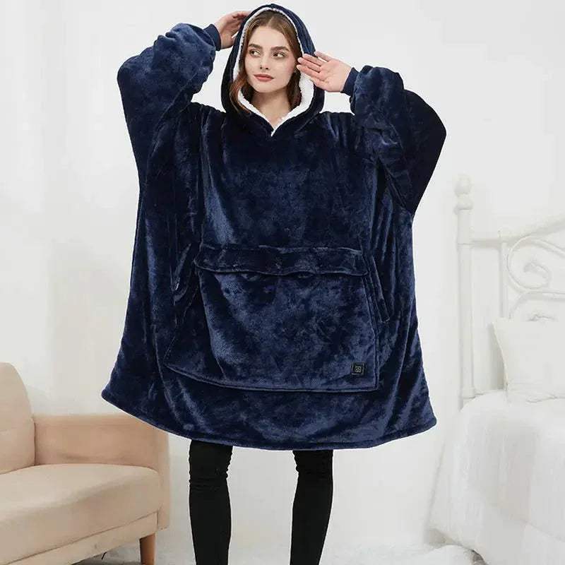 Person wearing a navy blue fleece Oversized Heatable Hoodie with a hood in a minimalistic room.
